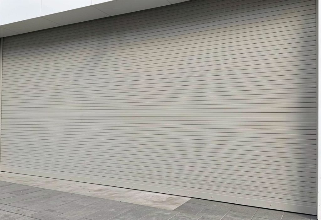 Cortina enrollable automática fabricada en fleje de seguridad tipo americano, calibre 22 galvanizado, equipada con motor lateral Elite 611 para automatización. Garantizando seguridad, resistencia y funcionamiento práctico para accesos comerciales o industriales.